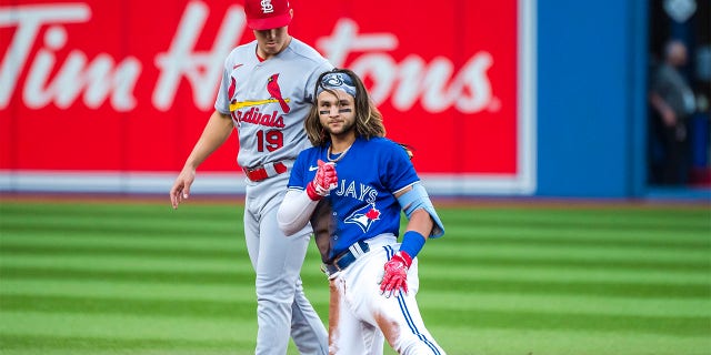 Toronto Blue Jays' Bo Bichette (11) gives a thumbs up after safely sliding into second base past St. Louis Cardinals shortstop Tommy Edman (19) for a double during the first inning of a baseball game, Tuesday, July 26, 2022 in Toronto.