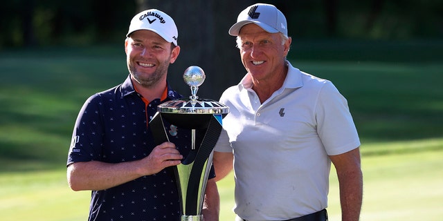 Branden Grace, left, and LIV Golf CEO Greg Norman, right, pose with the trophy after Grace won the Portland Invitational LIV Golf tournament in North Plains, Ore., Saturday, July 2, 2022. 
