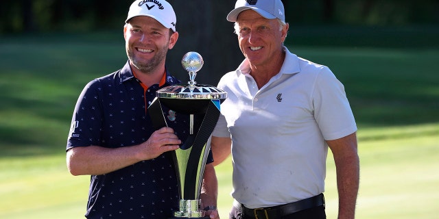 Branden Grace, left, and LIV Golf CEO Greg Norman, right, pose with the trophy after Grace won the Portland Invitational LIV Golf tournament in North Plains, Ore., Saturday, July 2, 2022.