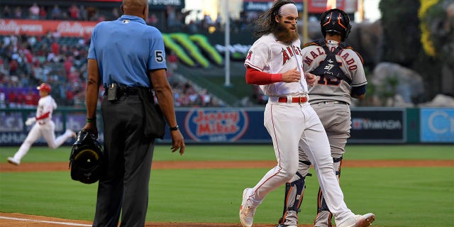 Los Angeles Angels' Brandon Marsh, second from right, scores on a triple by Shohei Ohtani, left, as Houston Astros catcher Martin Maldonado stands at the plate during the second inning of a baseball game Wednesday, July 13, 2022, in Anaheim, Calif.