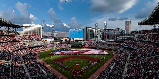 F-16s fly over during the national anthem before a baseball game between the Atlanta Braves and the St. Louis Cardinals, Monday, July 4, 2022, in Atlanta. 