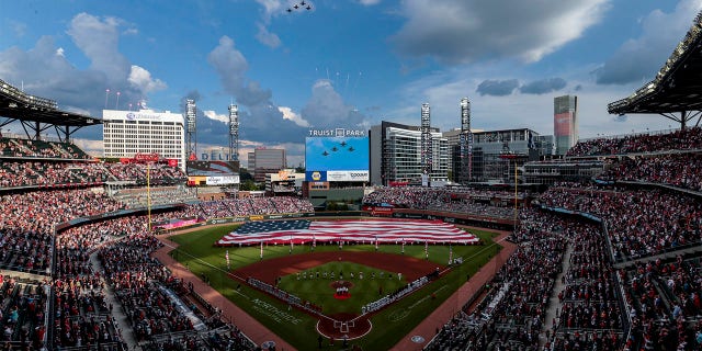 F-16s fly over during the national anthem before a baseball game between the Atlanta Braves and the St. Louis Cardinals, Monday, July 4, 2022, in Atlanta. 