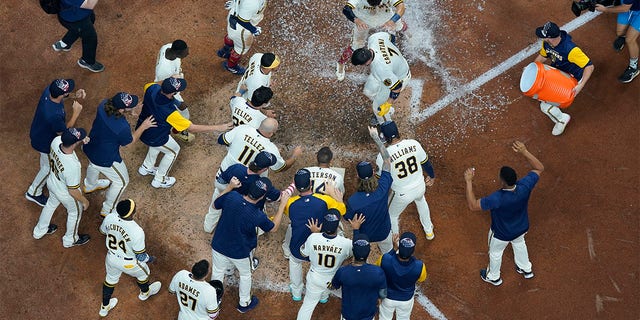 Milwaukee Brewers' Victor Caratini is congratulated after hitting a walk off three run home run during the 10th inning of a baseball game against the Chicago Cubs Monday, July 4, 2022, in Milwaukee. 