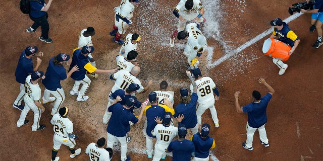 Milwaukee Brewers' Victor Caratini is congratulated after hitting a walk off three run home run during the 10th inning of a baseball game against the Chicago Cubs Monday, July 4, 2022, in Milwaukee.