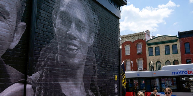 An alleyway past a street depicting WNBA star Brittany Griner, top left, and other American hostages and wrongful detainees being held abroad in the Georgetown neighborhood of Washington, Wednesday, July 20, 2022.
