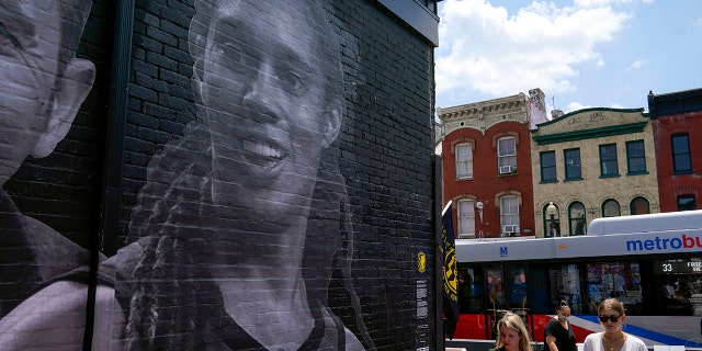 An alley past a mural depicting WNBA star Brittney Griner, top left, and other American hostages and wrongful detainees who are being held abroad Wednesday, July 20, 2022, in the Georgetown neighborhood of Washington.