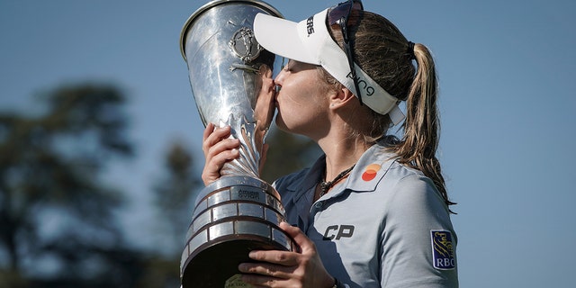 Brooke Henderson, of Canada, kisses with her trophy after winning the Evian Championship women's golf tournament in Evian, eastern France, Sunday, July 24, 2022.