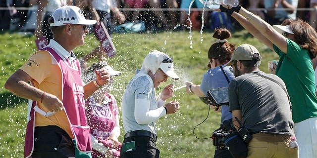 Brooke Henderson, of Canada, center, celebrates after winning the Evian Championship women's golf tournament in Evian, eastern France, Sunday, July 24, 2022.