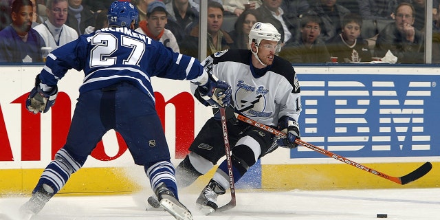 Brad Richards (19) of the Tampa Bay Lightning carries the puck as Bryan Marchment (27) of the Toronto Maple Leafs lines him up for a check March 23, 2004, at Air Canada Centre in Toronto, Ontario, Canada.