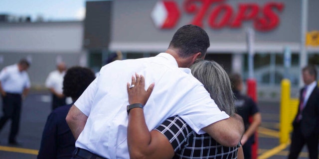 Buffalo Police Commissioner Joseph Gramaglia hugs Leah Holton-Pope, senior advisor to New York Assembly Majority Leader Peoples-Stokes prior to a ceremony to honor the victims on the two-month anniversary of the attack by a racist gunman at a memorial outside the store in Buffalo, N.Y., Thursday, July 14, 2022.