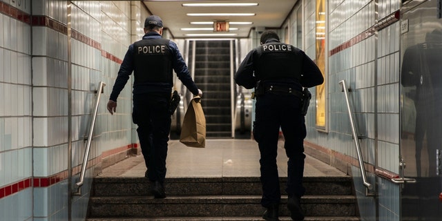 Chicago police officers walk through the CTA Red Line State/Lake station while working the scene where a 27-year-old man and 55-year-old man were shot on the 100 block of North Wabash in the Loop, Sunday, May 1, 2022, in Chicago. 