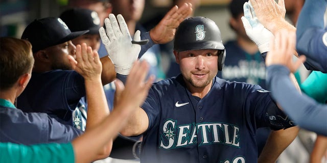 Seattle Mariners' Cal Raleigh is greeted in the dugout after he hit a solo home run against the Texas Rangers during the seventh inning of a baseball game, Tuesday, July 26, 2022, in Seattle.