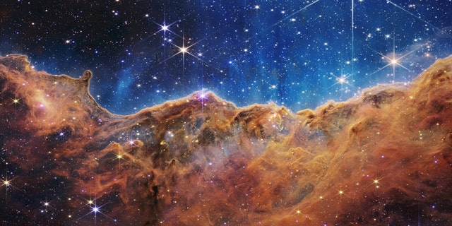 То, что в лунный вечер очень похоже на скалистые горы, на самом деле является краем соседней молодой области звездообразования NGC 3324 в туманности Киля.  Это изображение, полученное в инфракрасном свете камерой ближнего инфракрасного диапазона (NIRCam) космического телескопа Джеймса Уэбба НАСА, показывает ранее закрытые области рождения звезд.