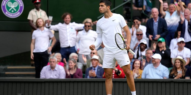 Spain's Carlos Alcaraz celebrates winning the third set against Italy's Jannik Sinner during a men's fourth round singles match on day seven of the Wimbledon tennis championships in London, Sunday, July 3, 2022.