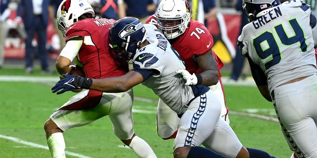 Carlos Dunlap of the Seattle Seahawks sacks Kyler Murray of the Arizona Cardinals during the fourth quarter at State Farm Stadium in Glendale, Ariz., on Jan. 9, 2022.