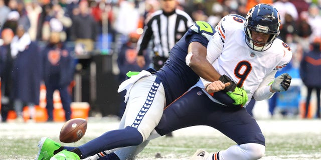 Nick Foles of the Chicago Bears fumbles the ball while hit by Carlos Dunlap of the Seattle Seahawks during the fourth quarter at Lumen Field in Seattle on Dec. 26, 2021.