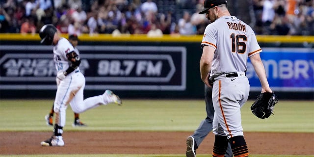 San Francisco Giants starting pitcher Carlos Rodon (16) walks around the mound after giving up a three-run home run to Arizona Diamondbacks' Christian Walker, left, during the third inning of a baseball game Tuesday, July 26, 2022, in Phoenix. 