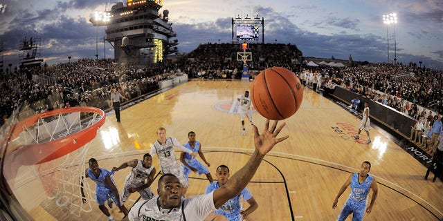 In this image taken with a fisheye lens, Michigan State center Derrick Nix (25) grabs a rebound in front of North Carolina forward John Henson (31), right, during the first half of the Carrier Classic NCAA college basketball game aboard the USS Carl Vinson, Friday, Nov. 11, 2011, in Coronado, Calif. 