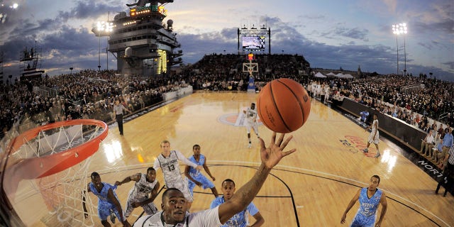 In this image taken with a fisheye lens, Michigan State center Derrick Nix (25) grabs a rebound in front of North Carolina forward John Henson (31), right, during the first half of the Carrier Classic NCAA college basketball game aboard the USS Carl Vinson, Friday, Nov. 11, 2011, in Coronado, Calif.
