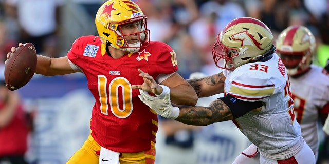 O quarterback do Philadelphia Stars, Case Cooks, é pressionado pelo Birmingham Stallions dentro do linebacker Scooby Wright durante a primeira metade de um jogo de futebol americano da USFL pelo campeonato da liga, domingo, julho.  3, 2022, em Canton, Ohio. 