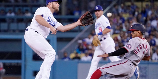 Washington Nationals' Cesar Hernandez, right, steals second as Los Angeles Dodgers third baseman Max Muncy takes a late throw from home during the fourth inning of a baseball game Monday, July 25, 2022, in Los Angeles.