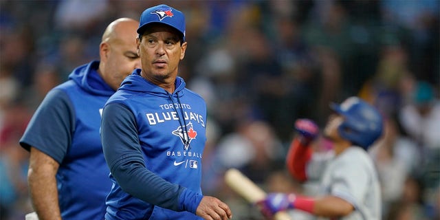 Toronto Blue Jays manager Charlie Montoyo walks with a trainer after Bradley Zimmer was hit by a pitch during the seventh inning of the team's baseball game against the Seattle Mariners, Thursday, July 7, 2022, in Seattle. Zimmer stayed in the game. 