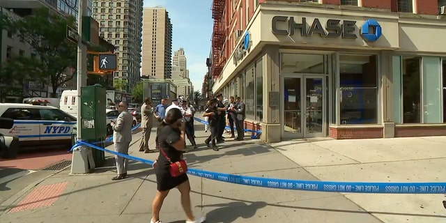 A tape of police blocks the area surrounding the Manhattan Chase bank where a security guard was seriously injured by a knife-wielding suspect on Friday morning.