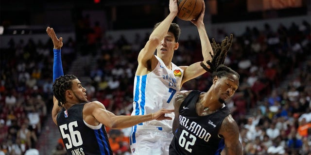 Oklahoma City Thunder's Chet Holmgren passes around Orlando Magic's Justin James, left, and Orlando Magic's Emanuel Terry, right, during the first half an NBA summer league basketball game Monday, July 11, 2022, in Las Vegas.