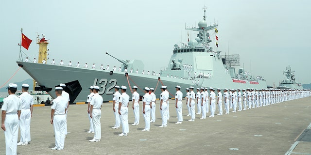 Miembros de la marina china se paran en el destructor de misiles guiados de Suzhou el 18 de mayo de 2022, en Zhoushan, provincia china de Zhejiang.