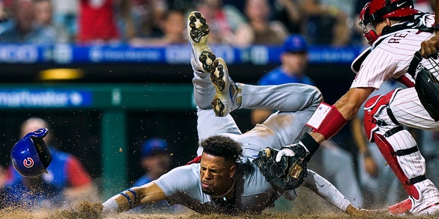 The Chicago Cubs' Christopher Morel scores past Philadelphia Phillies catcher J.T. Realmuto in the 10th inning Saturday, July 23, 2022, in Philadelphia.