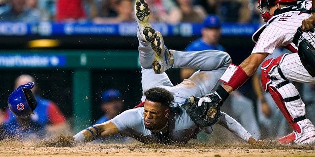 The Chicago Cubs' Christopher Morel scores past Philadelphia Phillies catcher J.T. Realmuto in the 10th inning Saturday, July 23, 2022, in Philadelphia.