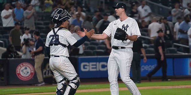 New York Yankees catcher Jose Trevino, left, slap hands with relief pitcher Clay Holmes (35) after the team's win over the Tampa Bay Rays in a baseball game Tuesday June 14, 2022, in New York.