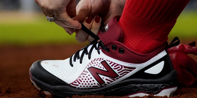 U.S. Representative Kat Cammack (R-FL) ties her shoes during the annual Congressional Baseball game at Nationals Park in Washington, Sept. 29, 2021.