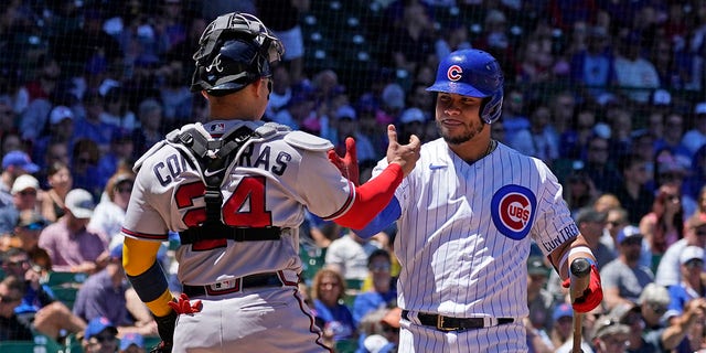 Wilson Contreras of the Chicago Cubs (right) greets his brother, Atlanta Braves catcher William Contreras during the first half of a baseball game in Chicago, Saturday, June 18, 2022. 