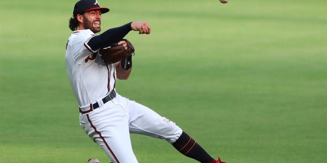 Atlanta Braves shortstop Dansby Swanson slips to one knee while making a play on a ground ball by New York Mets Mark Canha during the first inning in a baseball game on Tuesday, July 12, 2022, in Atlanta.
