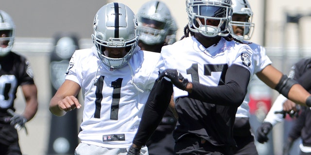 Wide receivers Demarcus Robinson, left, and Davante Adams of the Las Vegas Raiders warm up during mandatory minicamp on June 7, 2022, in Henderson, Nevada.