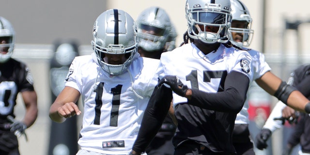 Wide receivers Demarcus Robinson, left, and Davante Adams of the Las Vegas Raiders warm up during mandatory minicamp on June 7, 2022, in Henderson, Nevada.