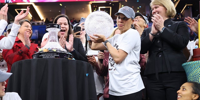 After defeating UConn Huskies in the NCAA Women's Basketball Tournament Championship Game at Target Center on April 3, 2022 in Minneapolis, Minnesota, South Carolina Gamecock head coach Dawn Staley receives a WBCA coach trophy.
