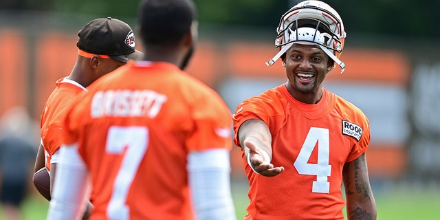 Cleveland Browns quarterback Deshaun Watson, right, talks with quarterback Jacoby Brissett during practice in Berea, Ohio, on Friday, July 29, 2022.