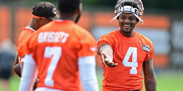 Cleveland Browns quarterback Deshaun Watson, right, talks with quarterback Jacoby Brissett during an NFL football practice in Berea, Ohio, Friday, July 29, 2022.