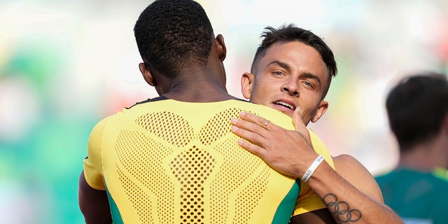 Devon Allen of the USA hugs Jamaica's Hansle Perchmenta in the semi-finals of the men's 110m hurdles at the World Championships in Athletics on Sunday, July 17, 2022 in Eugene, Oregon.