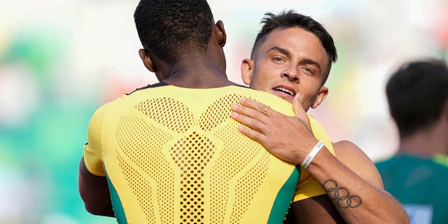 Devon Allen, of the United States, embraces Hansle Parchment, of Jamaica, in a semi-final heat in the men's 110-meter hurdles at the World Athletics Championships on Sunday, July 17, 2022, in Eugene, Ore.