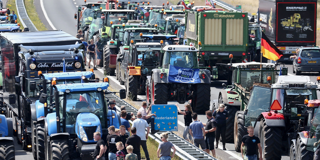 Farmers gather with their vehicles next to a border sign between the Netherlands and Germany on the A1 motorway, near Rijssen, June 29, 2022, during a protest against the Dutch government's nitrogen plans, 