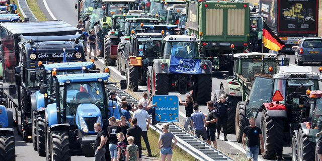 Farmers gather with their vehicles next to a border sign between the Netherlands and Germany on the A1 motorway, near Rijssen, June 29, 2022, during a protest against the Dutch government's nitrogen plans, 