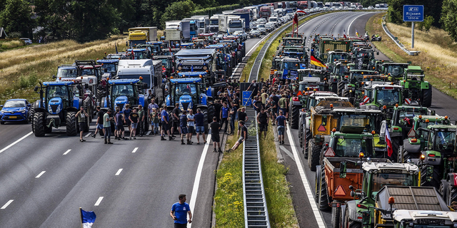 Farmers gather with their vehicles next to a Germany/Netherlands border sign to protest climate initiatives (Photo by VINCENT JANNINK/ANP/AFP via Getty Images) 