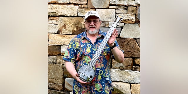 Indiana University professor and instrument collector Nicholas Toth displays his circa 1934 Rickenbacker Frying Pan, the earliest electric guitar.  He purchased it at Gruhn Guitars in Nashville in 2022 and loaned it to the Rock Hall of Fame in Cleveland. 