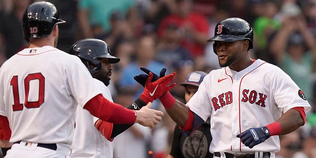 Boston Red Sox's Franchy Cordero, right, celebrates with Trevor Story (10) and Jackie Bradley Jr., behind left, after hitting a two-run home run allowing Story to score in the second inning of a baseball game against the New York Yankees, Sunday, July 10, 2022, in Boston. 
