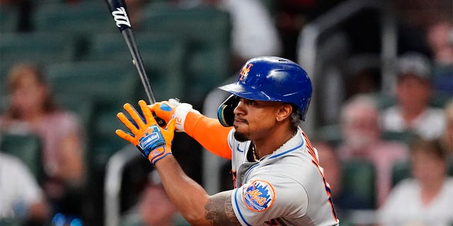 New York Mets shortstop Francisco Lindor (12) drives in a run with a triple in the fifth inning of a baseball game against the Atlanta Braves Tuesday, July 12, 2022, in Atlanta.
