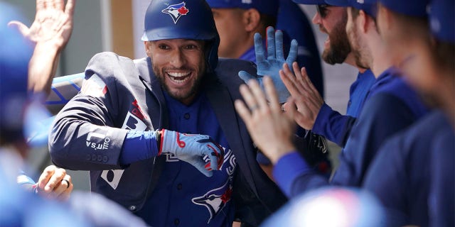 Toronto Blue Jays' George Springer wears the team's traditional home run jacket as he celebrates with teammates in the dugout after he hit a solo home run during the first inning of a baseball game against the Seattle Mariners, Domenica, luglio 10, 2022, a Seattle.