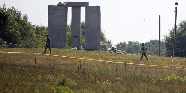 Law enforcement officials walk around the damaged Georgia Guidestones monument near Elberton, Ga., on Wednesday, July 6.